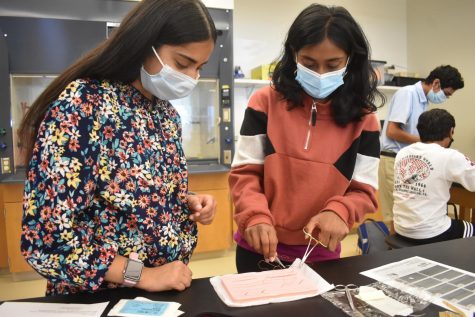 President Saivi Gadi and Amisha Poojari work on sutures.