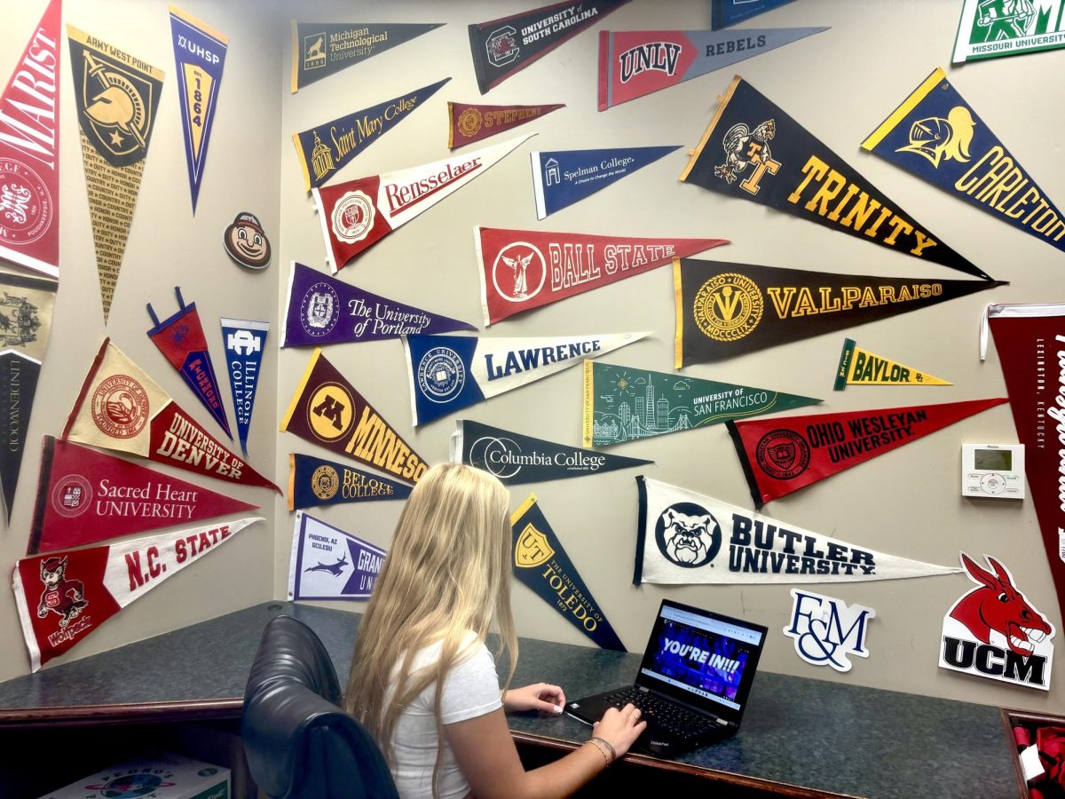 Surrounded by college pennants in the College Counseling office, Jackie Giljum ‘26 views her acceptance to Texas Christian University on her computer, April 17. Giljum plans to attend TCU next year, majoring in criminology on the pre-law track.