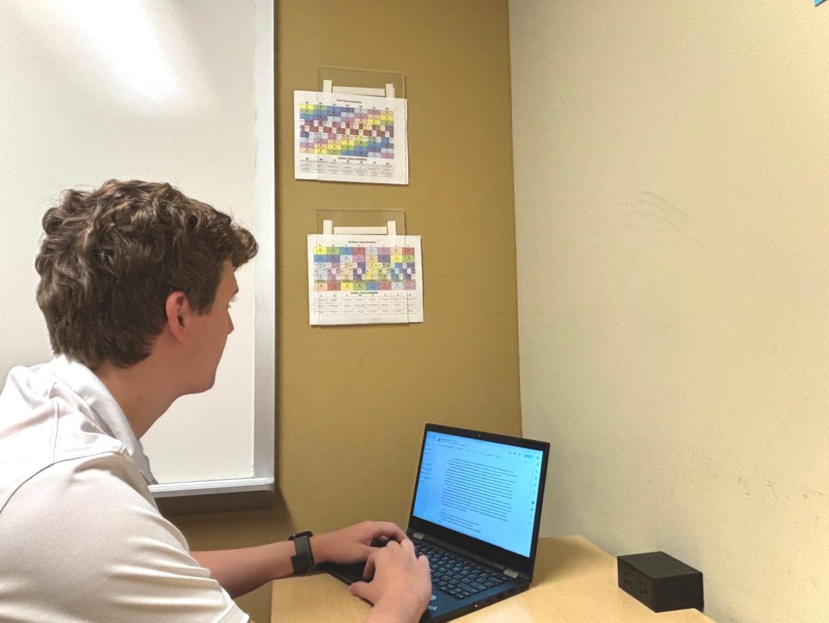 Colorful block day and 9-day schedules hang on the wall as Lewis Adkins ’26 works on a Spanish 550 assignment in the academic center. MICDS has 15 different daily schedules, excluding special schedules, and these papers are a frequent sight across campus.