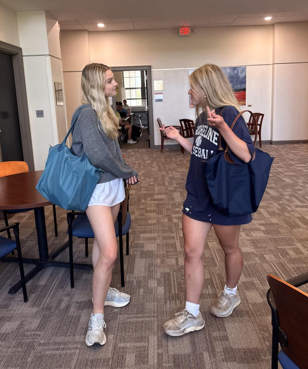 Discussing their schedules in the hallways, Lexie Kummant ‘26 talks with Charlotte Medler ‘26. Both Kummant and Medler are carrying Longchamp Le Pliage Original L Tote bags.